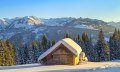 Verschneite Hütte vor Allgäuer Winterpanorama © Dominic Ultes