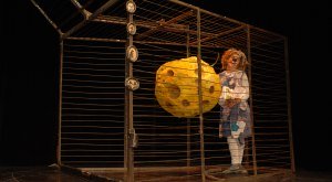 Als Maus verkleideter Schauspieler steht in einem Käfig mit einem großen Stück Käse. © Gardi Hutter Als Maus verkleideter Schauspieler steht in einem Käfig mit einem großen Stück Käse. © Gardi Hutter