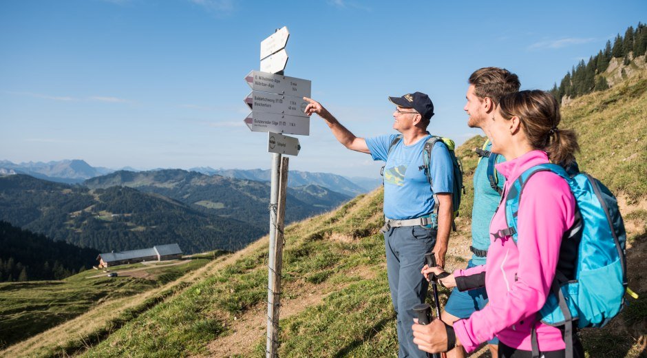 Ein Wegweiser zeigt die Richtung der Wanderwege an, um den Wanderern die Orientierung auf der anspruchsvollen 4-Gipfel-Tour zu erleichtern. Der Weg führt durch eine wunderschöne Berglandschaft. © Tourismus Hörnerdörfer, F. Kjer