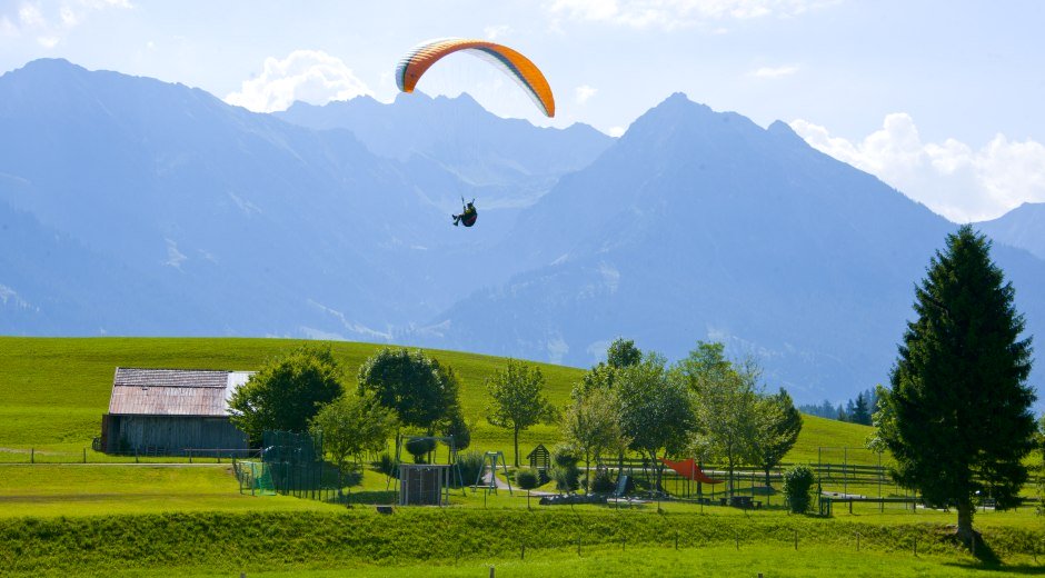 Gleitschirmflieger kurz vor der Landung beim Restaurant Kitzebichl in Bolsterlang